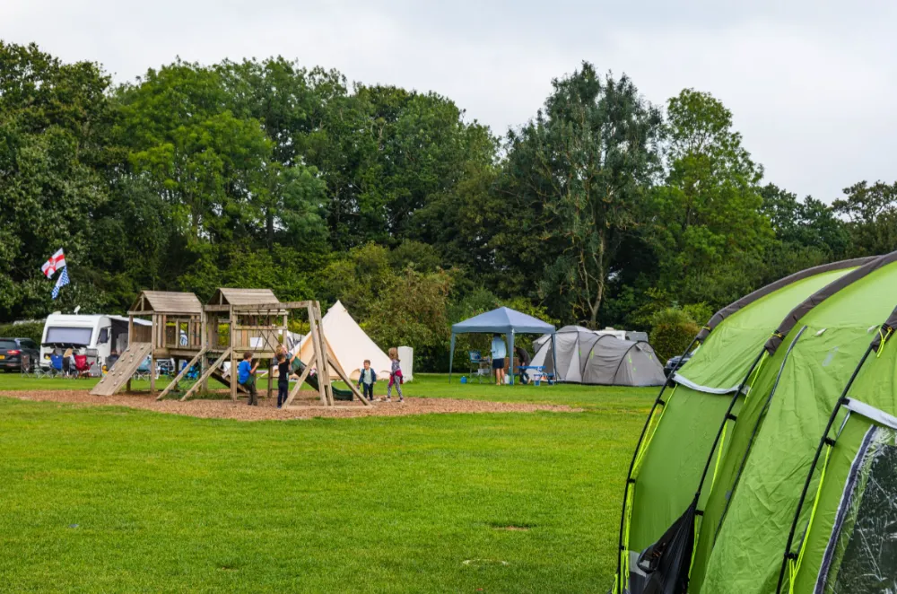 Family camping checklist | Family camping field with climbing frame.