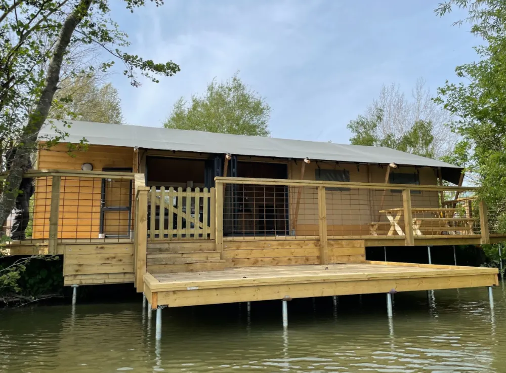 Safari tent | Safari tent accommodation on the side of a lake.