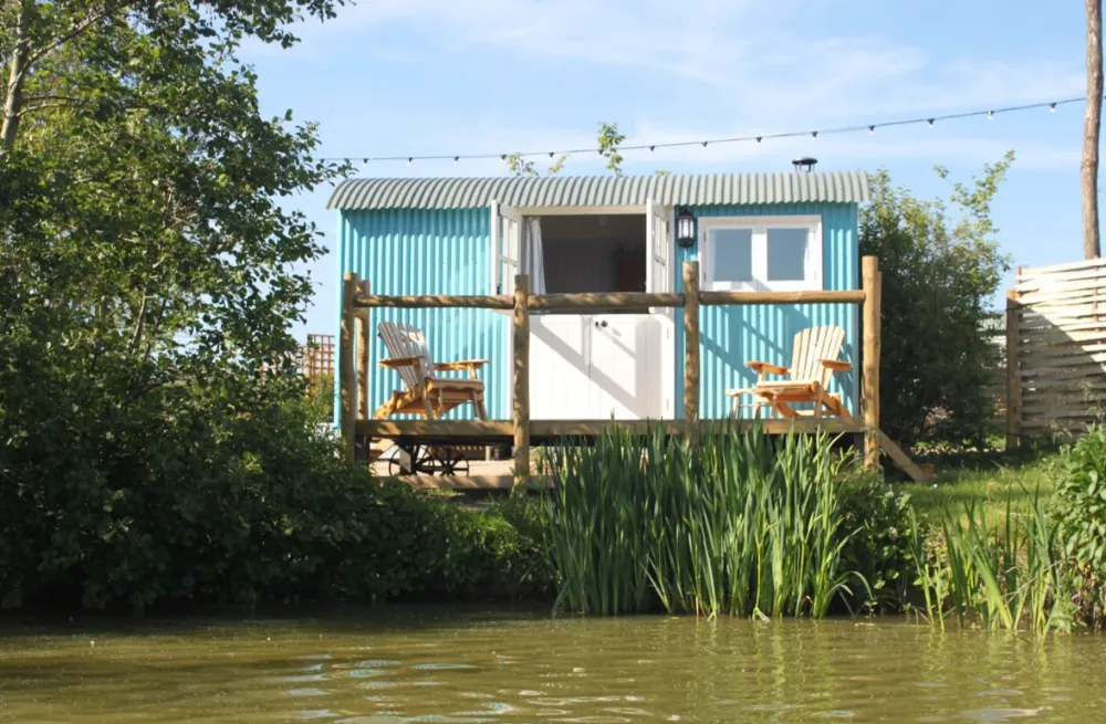 Shepherd's Huts | Shepherd hut on bank of lake.